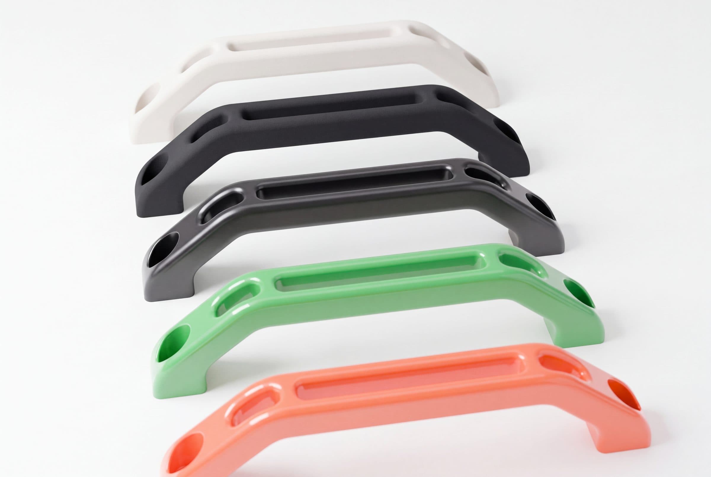 The same handle in five finishes: raw, black, vapour-smoothed, green paint, orange paint