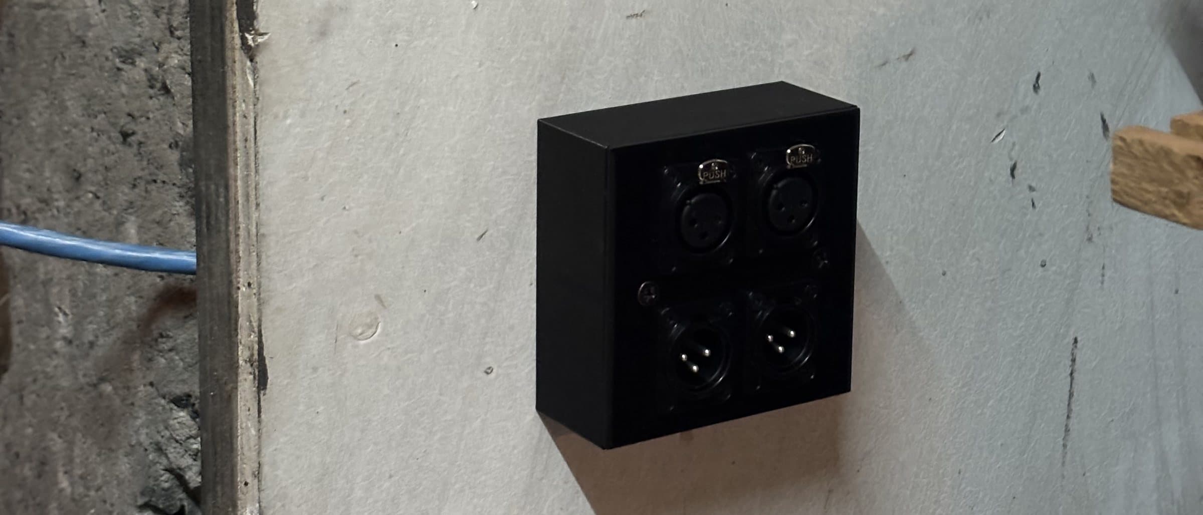 Gotowa puszka z płytką 4× XLR na ścianie studia, kabel poprowadzony po ścianie.