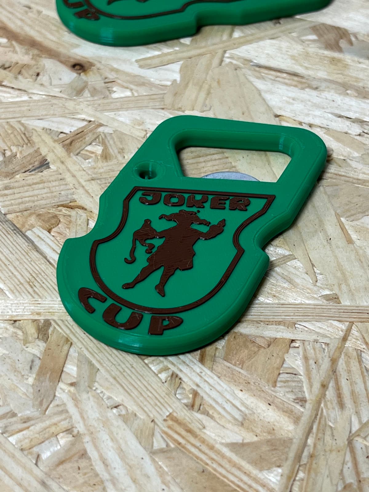 Wydrukowany otwieracz JOKER CUP z bliska, widoczny wytłoczony herb i napis na zielonym korpusie.