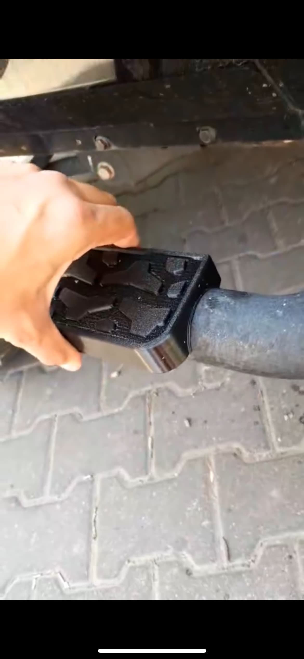 Detal mocowania stopnia na końcu rurowej belki, dłoń dla skali.